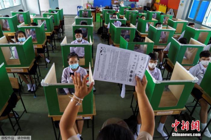 资料图：当地时间2020年7月1日，泰国巴吞他尼府，学校恢复上课，把旧投票箱放在课桌上帮助学生保持社交距离。